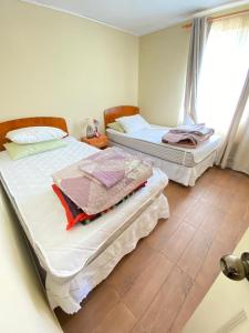 two beds sitting in a room with a window at Casa Haciendado de Lolol in Alto de Nerquihue +1 photo