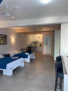 a room with three beds and a kitchen at Condo Marena in Playa del Carmen