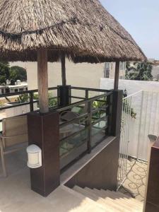 a balcony with a straw umbrella and a toilet at Condo Marena in Playa del Carmen