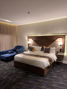 a hotel room with a large bed and a chair at فندق وند wand hotel in Khawājīyah