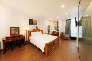 a bedroom with a bed and a desk and a television at Sài Gòn Heat Hotel in Ho Chi Minh City