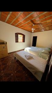 a bedroom with two beds and a wooden ceiling at Sítio Montanhas Gerais in Sabará +24 photos