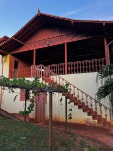 a house with a staircase in front of it at Sítio Montanhas Gerais in Sabará