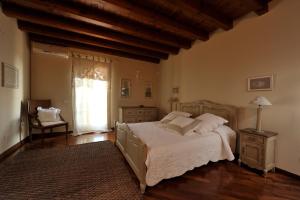 バルドリーノにあるTenuta La Càのベッドルーム1室(ベッド1台、椅子、窓付)