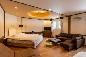 富良野市にあるホテルふらのヴェルデのベッドとソファのあるホテルの部屋