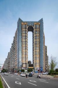 大面镇Home Inn Paibaiyun Hotel Chengdu Longquanyi Normal University Modern Garden Branch的路边有拱门的大楼