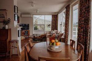 a living room with a table with a bowl of fruit on it at Beaumont at Freycinet in Coles Bay