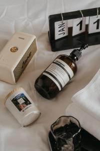 a bottle of alcohol and a cell phone on a bed at BANCOTAIMA DALAT Hotel in Da Lat