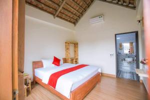 Un dormitorio con una cama con una manta roja y blanca. en Lodge By Tam Coc lake, en Ninh Binh