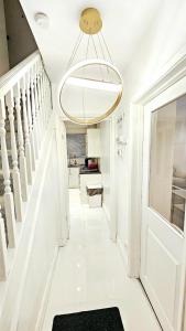 a white hallway with a door and a chandelier at Cosy and stylish 3 bedroom house in Middleton