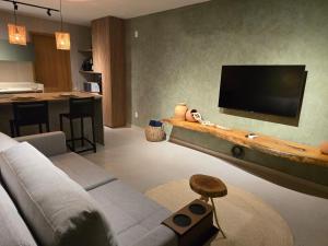 ein Wohnzimmer mit Sofa und Flachbildfernseher in der Unterkunft Casulo Milagres in São Miguel dos Milagres