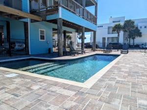 a swimming pool in front of a building at Blue Horizon at Pensacola Beach - Heated Pool, Across beach access, Beach gear, Dogs OK! in Pensacola Beach