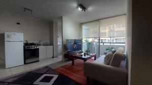 a living room with a couch and a kitchen at Estadía Bertita in Talca