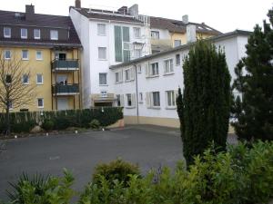 un estacionamiento frente a algunos edificios en Hotel Alfa en Neu Isenburg