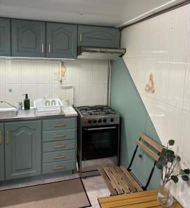 a kitchen with green cabinets and a stove and a bench at Aurora's Lighthouse - Caminhos de Santiago in Vila Chã +13 photos