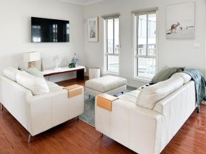 a white living room with two white couches at Coastal Sanctuary, Spa, EV friendly, Pet Firendly with Fireplace, wood provided Just 50m to Kilcunda Beach and 100m to the Ocean View Hotel The Sticks and Copper Door Kitchen Accessibility Friendly in Kilcunda