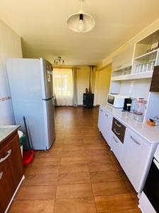 a kitchen with a white refrigerator and a wooden floor at Casa Haciendado de Lolol in Alto de Nerquihue