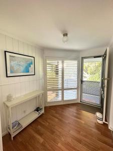 a living room with wooden floors and white walls at Water Front in Saint Margaret Island