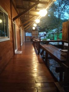 a row of wooden tables and benches in a restaurant at Banpoo in Ko Yao Noi