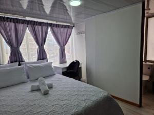 sypialnia z dużym łóżkiem z fioletowymi zasłonami w obiekcie Habitación baño privado garaje moto, Manizales w mieście Manizales