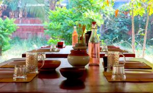 a wooden table with a bottle of wine on it at Clayfingers Art Cottage in Trichūr