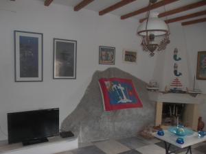 a living room with a tv and a fireplace at Theodora's House in Hydra