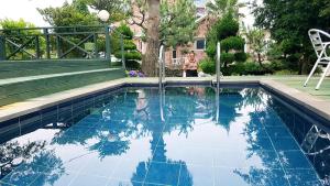 une femme debout à côté d'une piscine dans l'établissement 제주동쪽숙소 제주곶자왈별장 ForestGarden TheHouseOfCottonClouds, à Jeju