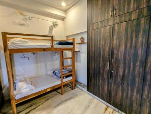 a small room with a bunk bed and a wooden door at Punia's Staycation in Udaipur