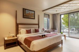 a bedroom with a large bed and a balcony at SaffronStays Pristine Manor - 8-BR Udaipur villa with private pool, garden, and event space near Fateh Sagar Lake in Udaipur