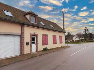 ein Gebäude mit roten Fensterläden an einer Straße in der Unterkunft Appartement cosy rénové près de Chartres - FR-1-581-147 in Le Boullay-Thierry