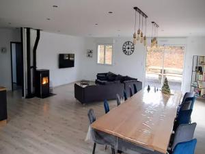 ein Wohnzimmer mit Tisch und Couch in der Unterkunft Grande maison 10 pers. avec bain nordique et jeux près des Vosges - FR-1-589-773 in Frémifontaine