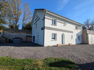 ein weißes Haus mit einem Zaun und einem Hof in der Unterkunft Grande maison 10 pers. avec bain nordique et jeux près des Vosges - FR-1-589-773 in Frémifontaine