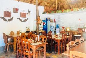 a dining room with wooden tables and chairs at RedDoorz Hostel at Deomar Hometel & Farm Cafe Vigan Ilocos in Bantaoay +19 photos