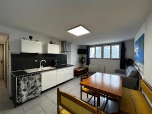 cocina y sala de estar con mesa y fregadero en T2 avec jardin, terrasse et Wifi à 1km des Thermes - FR-1-541-156, en La Roche-Posay
