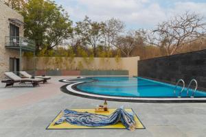 a swimming pool in the middle of a patio at SaffronStays Pristine Manor - 8-BR Udaipur villa with private pool, garden, and event space near Fateh Sagar Lake in Udaipur +46 photos