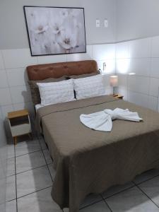 a bedroom with a bed with two towels on it at Hotel Glórias - Sonho 1 in Quirinópolis