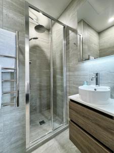 un baño con ducha y lavabo en City & Ponsonby Center Side 2 BDR Townhouse vs AC, en Auckland