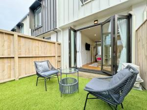 un patio con 2 sillas y una mesa de cristal en City & Ponsonby Center Side 2 BDR Townhouse vs AC, en Auckland