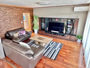 ein Wohnzimmer mit Sofa und Tisch in der Unterkunft Maria Hotel 宇都宮 in Utsunomiya