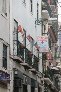 a building with balconies and signs on the side of it at Pensao Residencial Flor dos Cavaleiros in Lisbon