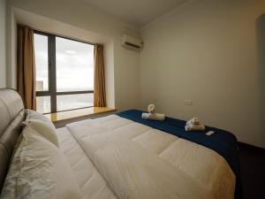 a bedroom with a large bed with two stuffed animals on it at 慕海Mosea悠享海景三卧房4806 in Johor Bahru +12 photos
