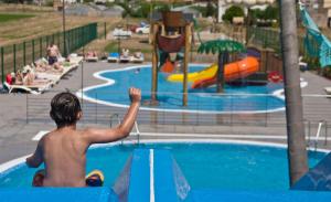 a young boy is looking at a water park at Hotel Europa Splash & Spa in Malgrat de Mar