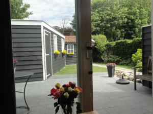 una puerta a un patio con un jarrón de flores en Vakantiewoning Duinoord Domburg, en Domburg