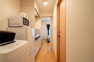a kitchen with a white refrigerator and a microwave at Belle Lead 206 in Tokyo