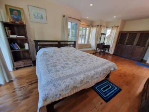 ein Schlafzimmer mit einem Bett und einem Holzboden in der Unterkunft บ้านชยชิโต Chayachito Home Stay in Ban Mo