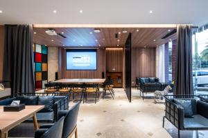 成都Home Inn Paibaiyun Hotel Chengdu Tianyu Road Subway Station Branch的配有桌椅和投影屏幕的会议室