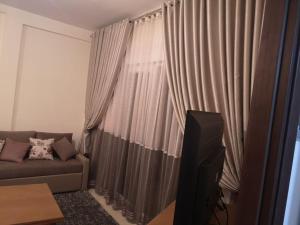Una sala de estar con un sofá y un televisor. en Apartment with pool in Sousse, en Akouda