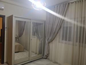 un espejo en una habitación con cortinas y un dormitorio en Apartment with pool in Sousse, en Akouda