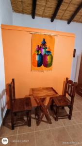 a table and two chairs and a painting on the wall at Tampu 4 alojamiento in Purmamarca