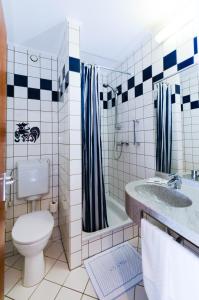 a bathroom with a toilet and a tub and a sink at Christophe Colomb in Luxembourg